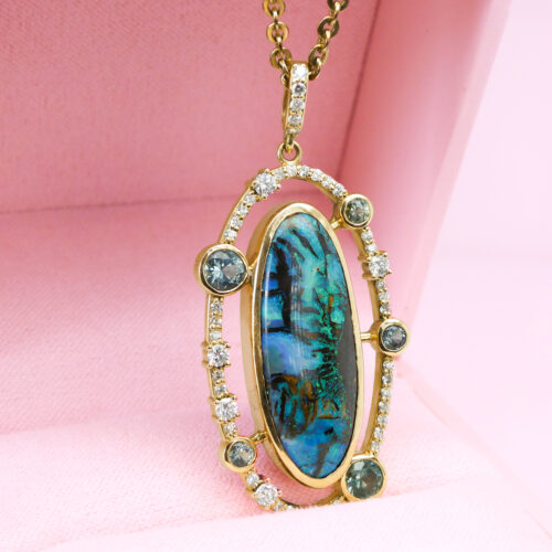 The magic of boulder opal is perfectly complimented by our detached halo of diamonds and Montana sapphires.