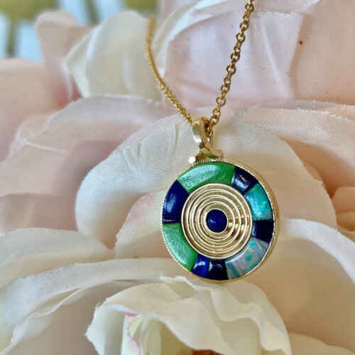 Add a special touch to your outfit with this beautiful pendant! Featuring opal, sapphire, turquoise, and lapis in luxe yellow gold.