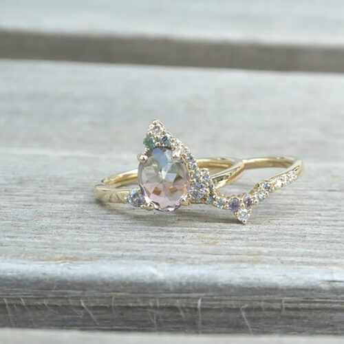 This custom ring set features an unusual bicolor spinel at its center, in a charming rose cut that keeps it low to the finger.  Accented with tiny spinels and diamonds in 14K gold,